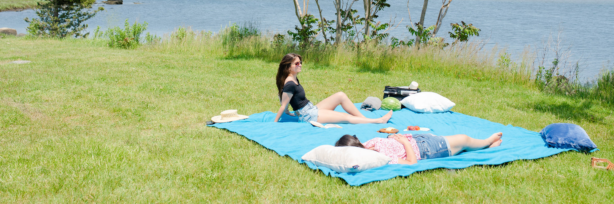 Peaceful Touch Fleece Picnic Blankets - Two girls sharing a light blue picnic blanket on a sunny spring day, American Blanket Company