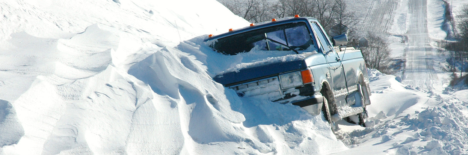 American Blanket Company - A blue pickup truck stuck in the snow