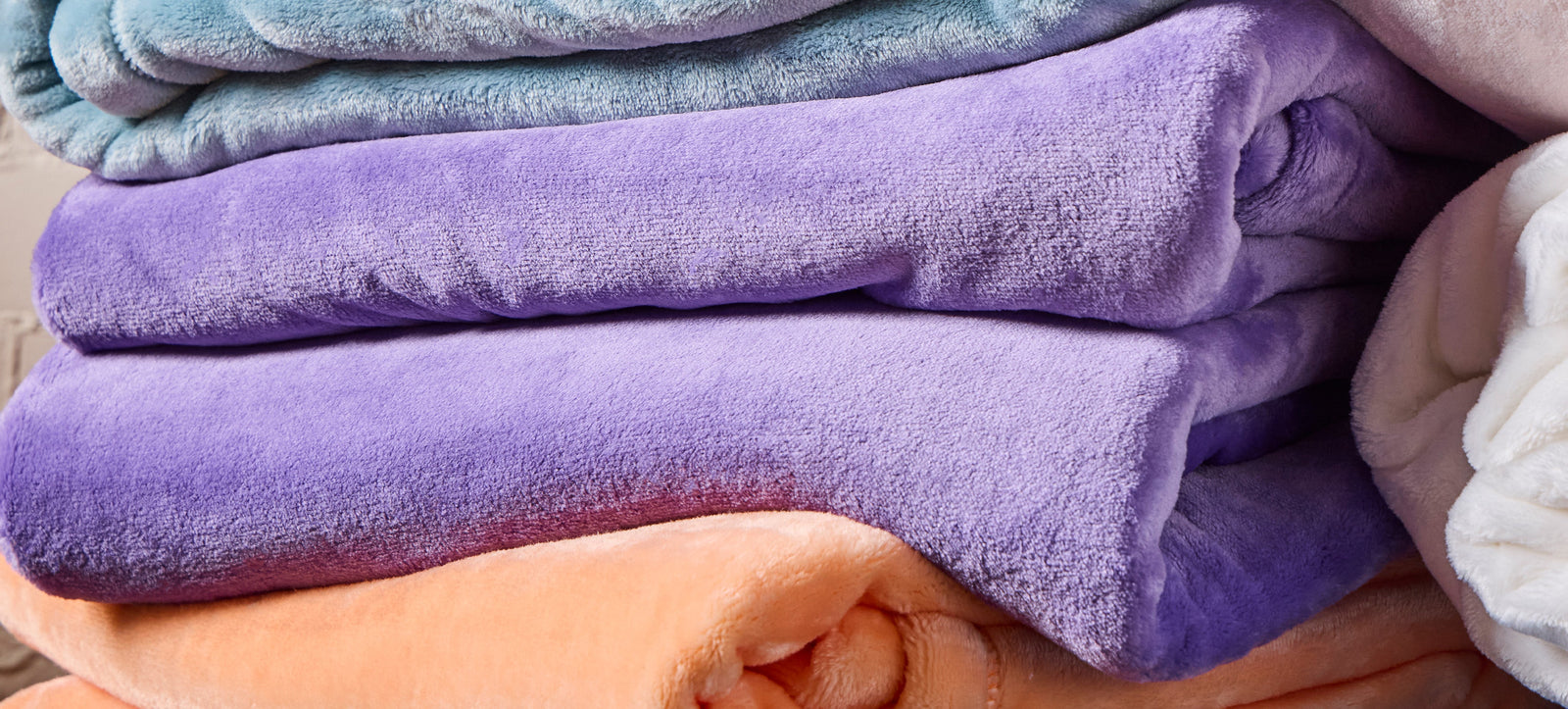 American Blanket Company - Fleece Throw Blankets - Pictured is various stacks of luster loft throw blankets