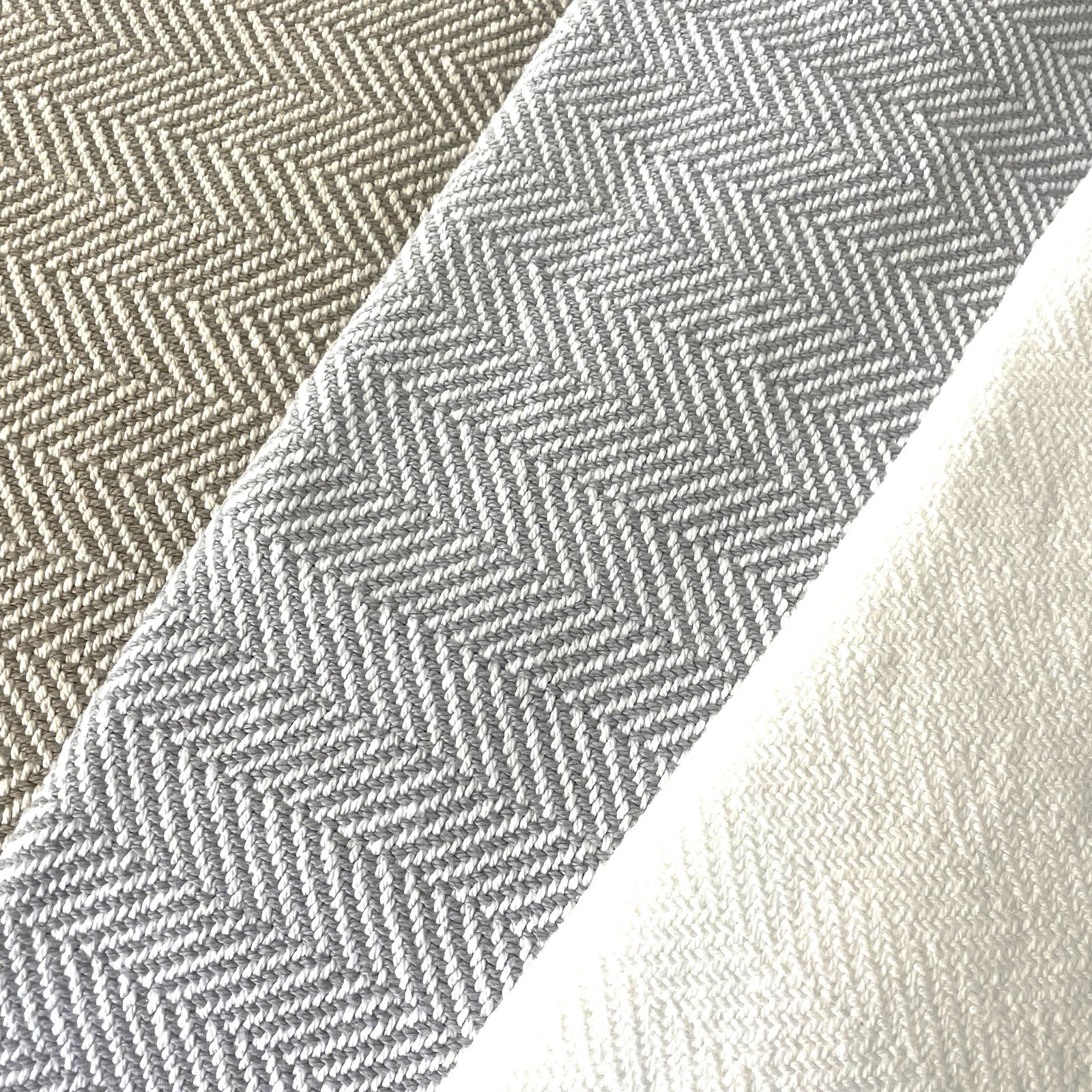 American Blanket Company - 100% Cotton Bed Blanket, Feather Weave Pattern Blanket - Fan out of the various blanket colors showing white, gray and white, and khaki and white in a lovely herringbone