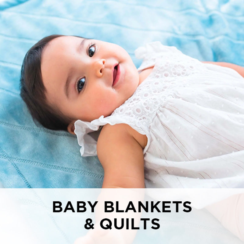 AMERICAN BLANKET COMPANY - FLEECE BABY BLANKETS - A BABY LYING ON A FLEECE LUSTER LOFT QUILT SMILING UP AT THE CAMERA