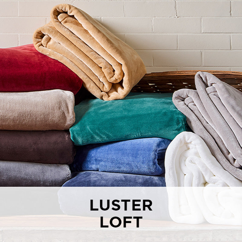 AMERICAN BLANKET COMPANY - LUSTER LOFT BLANKETS - COLORFUL STACKS OF LUSTER LOFT BLANKETS FALLING OUT OF A BASKET