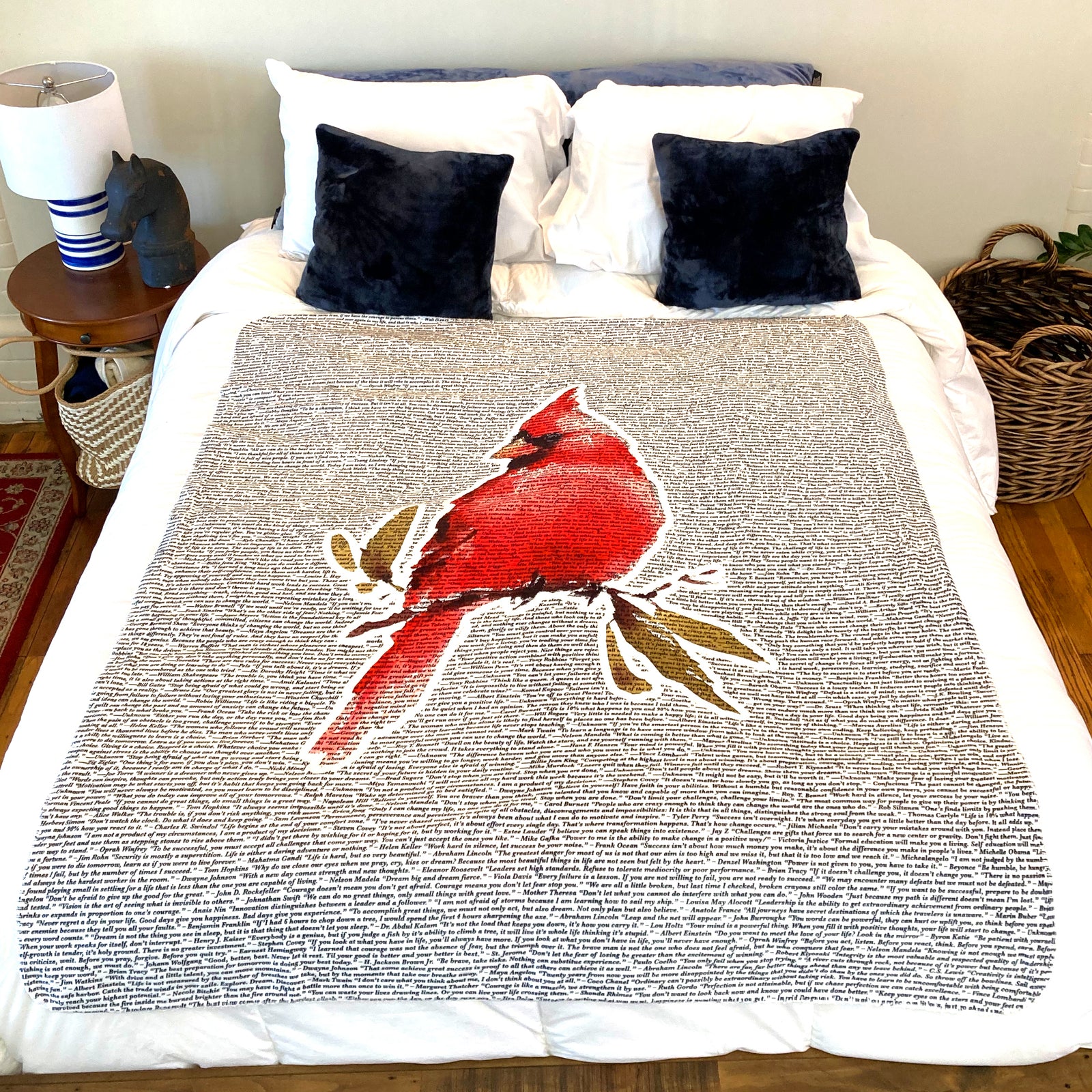 American Blanket Company - Cardinal Printed inspirational Quote blanket - A vibrant cardinal printed blanket laying on a cozy bed featuring quotes from many famous writers.