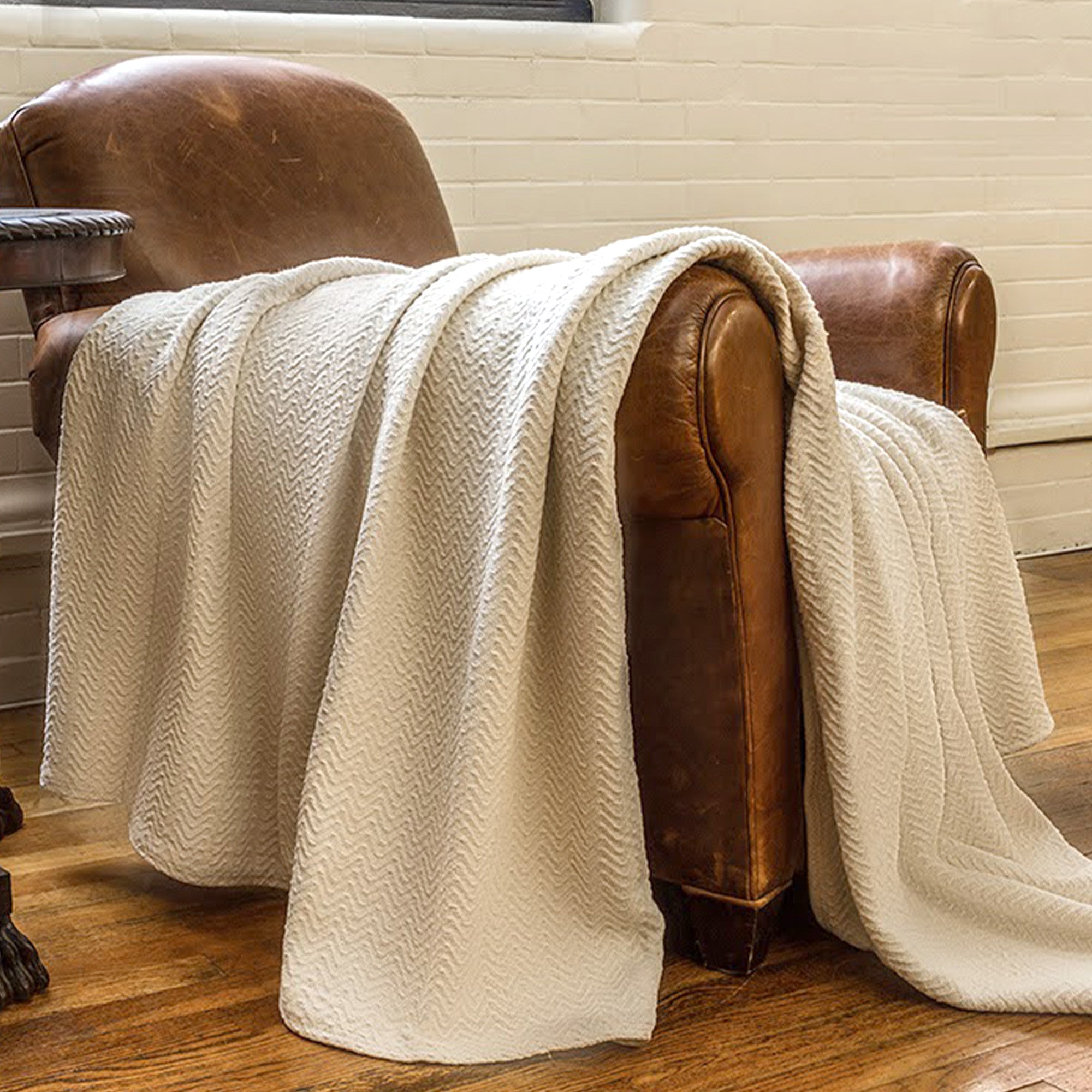 American Blanket Company - 100% Cotton Blanket, Chevron Weave - draped over leather armchair