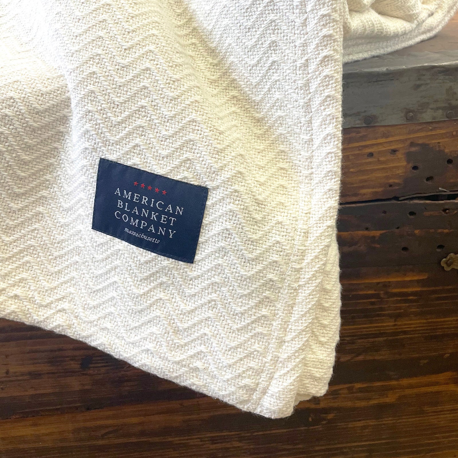 American Blanket Company - 100% Cotton Blanket, Chevron Weave - Draped over wooden chest