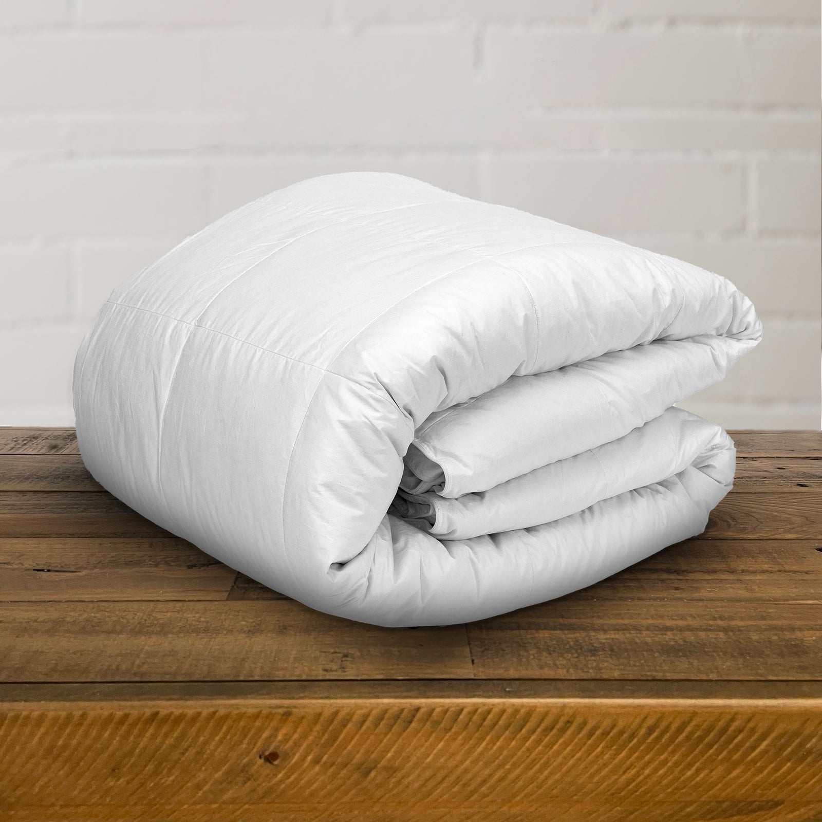 AMERICAN BLANKET COMPANY - DOWN COMFORTERS - A FOLDED, WHITE, THICK DOWN COMFORTER ON A WHITE BACKGROUND
